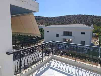 a balcony of a white building with a railing at Bright & comfortable apartment for a pleasant stay! in Vari