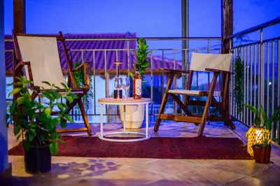 a balcony with two chairs and a bottle of wine at NoamansHouse SeaView near Airport in Artemida