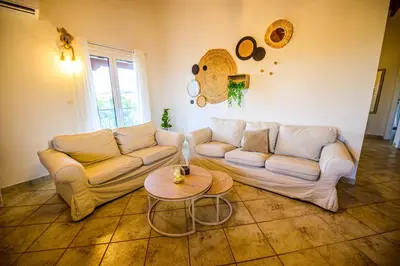 a living room with a couch and a table at NoamansHouse SeaView near Airport in Artemida