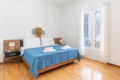 a bedroom with a large bed with a blue blanket at The Homely Hideaway in Athens