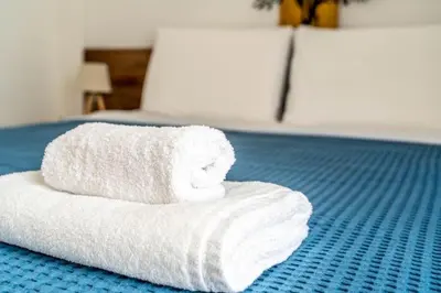a stack of white towels sitting on a bed at The Homely Hideaway in Athens