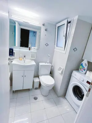 a bathroom with a toilet sink and a washing machine at City Center 2-Bedroom Sun home in Athens
