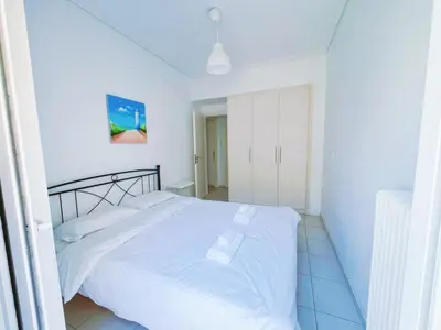 a white bed in a white bedroom with white walls at City Center 2-Bedroom Sun home in Athens