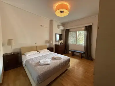 a bedroom with a large bed and a window at Casa Tierra Near ATH Airport in Markopoulo
