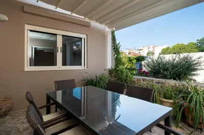 a patio with a glass table and chairs at Casa Tierra Near ATH Airport in Markopoulo
