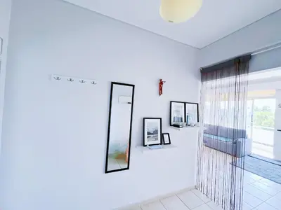 a white room with a mirror and a window at Spacious 2BR by Floisvos Beach Saltwater Balcony in Athens