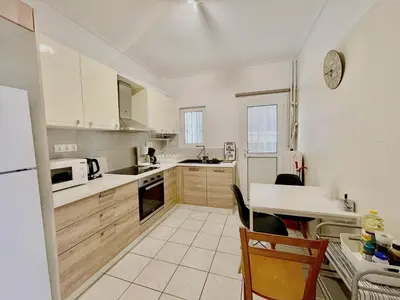 a kitchen with white cabinets and a white refrigerator at Spacious 2BR by Floisvos Beach Saltwater Balcony in Athens