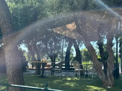 a table and chairs in a park with trees at Spacious 2BR by Floisvos Beach Saltwater Balcony in Athens