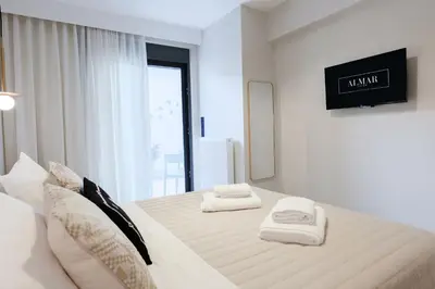a white bedroom with two towels on a bed at ALMARLIVING Stylish 2BR Apartment in Ilioupolis in Athens