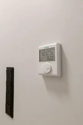 an alarm clock on a wall next to a black object at ALMARLIVING Stylish 2BR Apartment in Ilioupolis in Athens