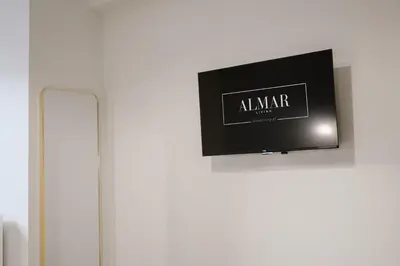 a television on a wall next to a radiator at ALMARLIVING Stylish 2BR Apartment in Ilioupolis in Athens