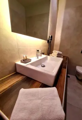 a bathroom with a white sink and a toilet at The George in Piraeus