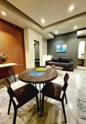 a living room with a table and chairs and a couch at The George in Piraeus