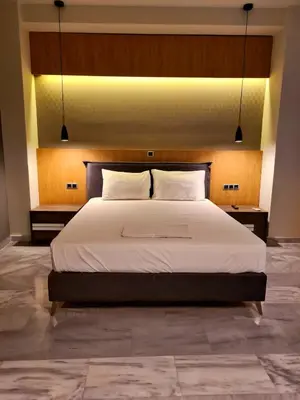 a bedroom with a large white bed with two pillows at The George in Piraeus