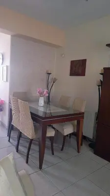 a dining room table and chairs with flowers on it at John & Mary's House Kalivia Near Sea & Athens Airport in Kalívia Thorikoú