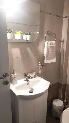 a bathroom with a white sink and a toilet at John & Mary's House Kalivia Near Sea & Athens Airport in Kalívia Thorikoú