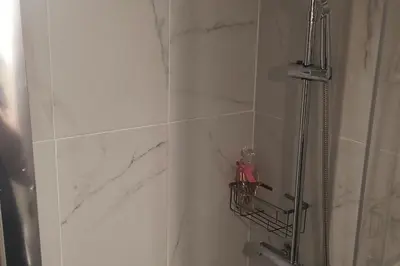 a bathroom with a shower and a marble wall at John & Mary's House Kalivia Near Sea & Athens Airport in Kalívia Thorikoú