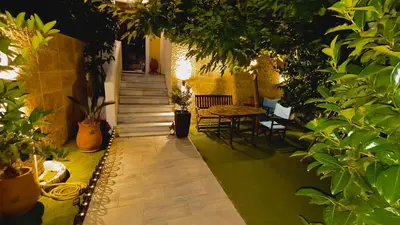 a hallway with a table and chairs and plants at John & Mary's House Kalivia Near Sea & Athens Airport in Kalívia Thorikoú