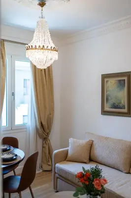 a living room with a couch and a chandelier at Athens Plaka Acropolis Suites in Athens