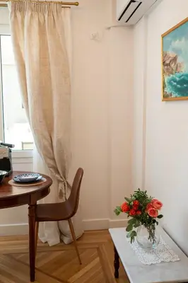 a room with a table and a vase of flowers on a table at Athens Plaka Acropolis Suites in Athens