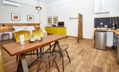 a kitchen and living room with a table and chairs at Aris Athens Suites in Athens