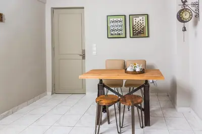 a dining room table with two chairs and a clock at Aris Athens Suites in Athens