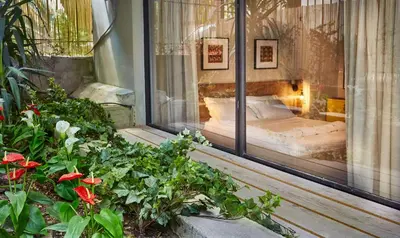 a bedroom with a bed in a window with flowers at Aris Athens Suites in Athens