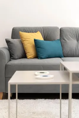 a grey couch with blue and yellow pillows and a coffee table at Athens Urban Apartment in Athens