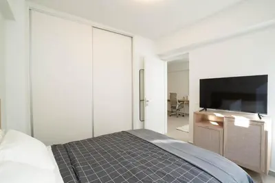 a bedroom with a bed and a flat screen tv at Athens Urban Apartment in Athens
