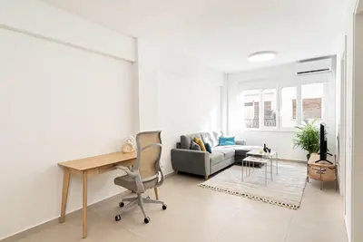 a white living room with a desk and a couch at Athens Urban Apartment in Athens