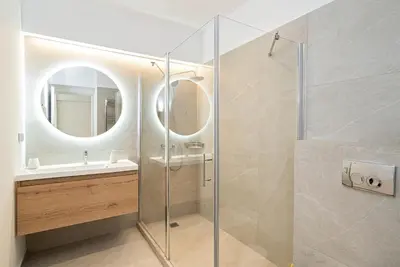 a bathroom with a shower and a sink and a mirror at Athens Urban Apartment in Athens