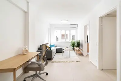 a white living room with a desk and chairs at Athens Urban Apartment in Athens