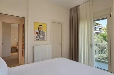 a white bedroom with a bed and a window at Prestige Lifestyle 3bd Apt in Kolonaki in Athens