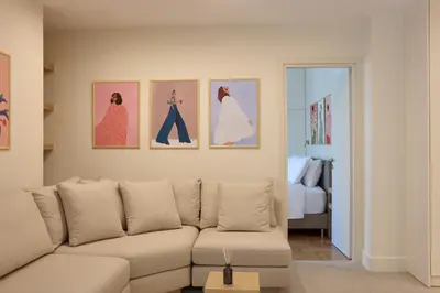 a living room with a couch and four pictures on the wall at Prestige Lifestyle 3bd Apt in Kolonaki in Athens