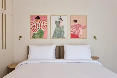 a bedroom with three paintings on the wall above a bed at Prestige Lifestyle 3bd Apt in Kolonaki in Athens