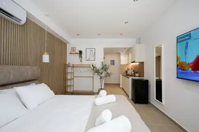 a bedroom with a white bed and a tv on a wall at O Suite - 105 in Athens
