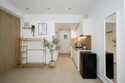 a kitchen with white walls and a counter with a plant at O Suite - 105 in Athens