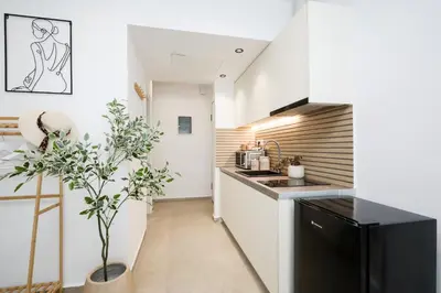 a kitchen with white cabinets and a black refrigerator at O Suite - 105 in Athens