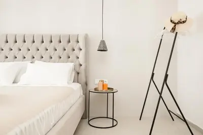 a bedroom with a bed and a floor lamp at O Suite - 106 in Athens