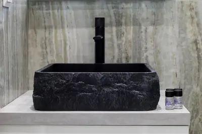 a black stone tub sitting on a counter with two bottles at O Suite - 106 in Athens