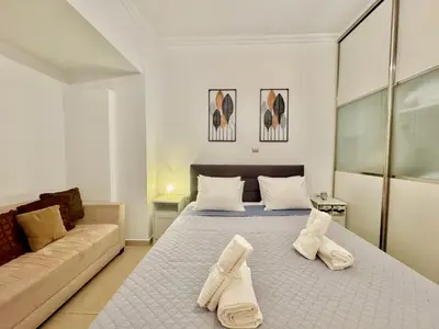 a bedroom with two beds and a couch at Marina Zeas Spacious Two Bedroom Apartment in Piraeus