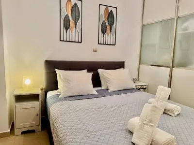 a bedroom with a bed with two towels on it at Marina Zeas Spacious Two Bedroom Apartment in Piraeus