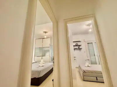 a mirror in a room with a bedroom and a bed at Marina Zeas Spacious Two Bedroom Apartment in Piraeus