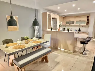 a kitchen and dining room with a table and chairs at Marina Zeas Spacious Two Bedroom Apartment in Piraeus