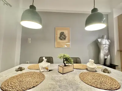 a dining room with a table with two chairs and two lights at Marina Zeas Spacious Two Bedroom Apartment in Piraeus