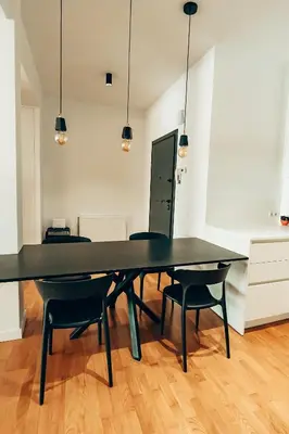 a black table and chairs in an empty room at 4 guests apartment near Glyfada center in Athens