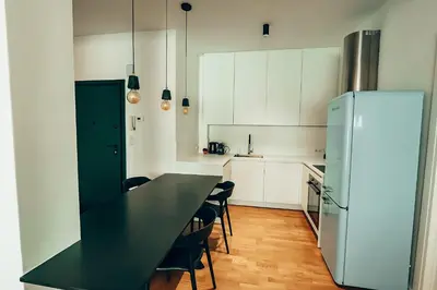 a kitchen with a black table and a refrigerator at 4 guests apartment near Glyfada center in Athens
