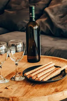 a table with a plate of crackers and a bottle of wine at 4 guests apartment near Glyfada center in Athens