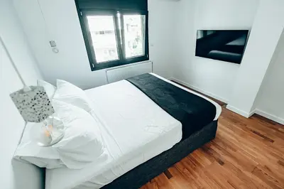a white bed in a room with a window at 4 guests apartment near Glyfada center in Athens