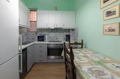 a kitchen with white cabinets and a table with chairs at Athens center traditional & classic 2BR apartment in Mesochórion